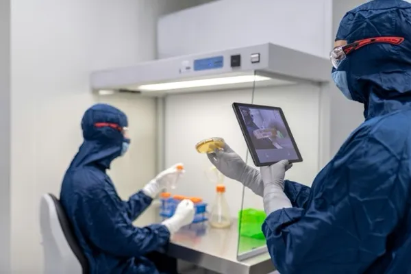 Cleanroom technicians collaborating with tablet